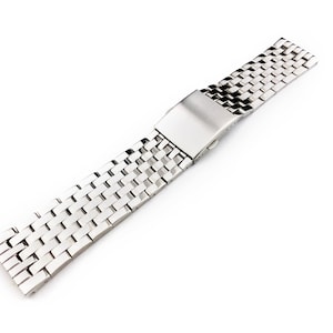 Peut inclure: Un bracelet de montre en métal argenté avec un fermoir. Le bracelet est composé de petits carrés liés.
