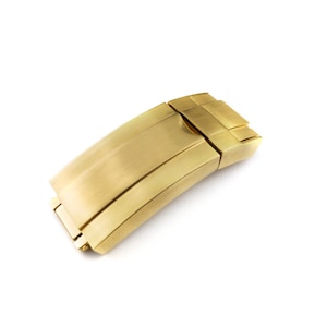 K&ouml;nnte beinhalten: Ein goldfarbener Metall-Uhrenarmbandverschluss mit geb&uuml;rsteter Oberfl&auml;che.