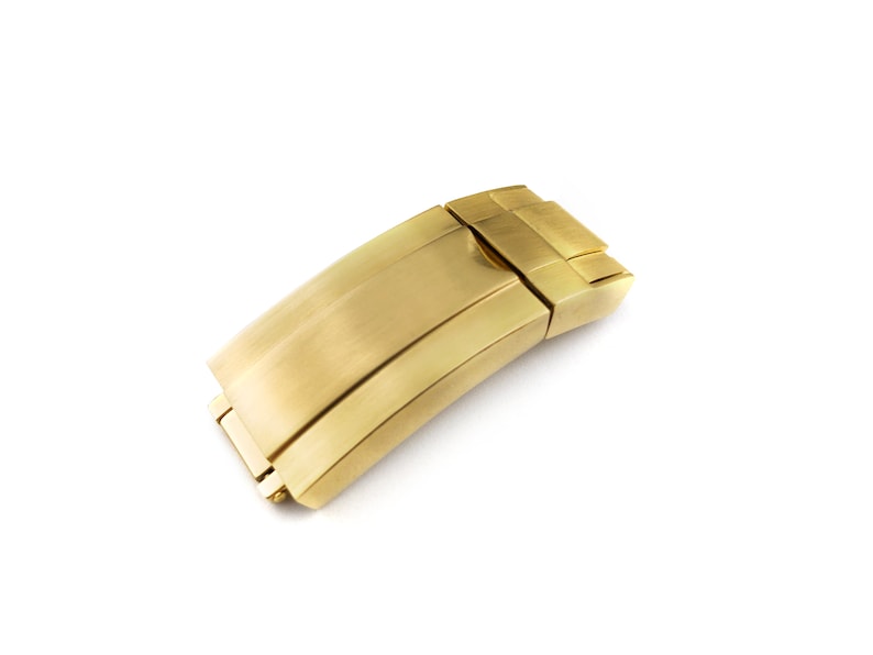 K&ouml;nnte beinhalten: Ein goldfarbener Metall-Uhrenarmbandverschluss mit geb&uuml;rsteter Oberfl&auml;che.