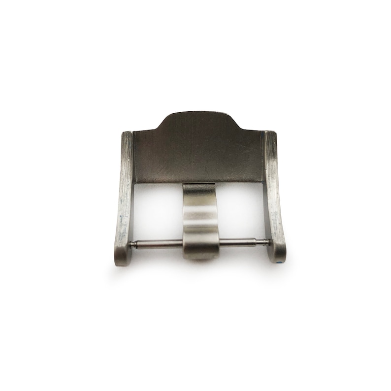 May include: A silver metal watch buckle with a smooth, brushed finish. The buckle has a simple, rectangular design with a single pin and a spring-loaded clasp.