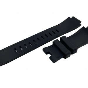 May include: Black rubber watch strap with a buckle and holes for adjusting the size.