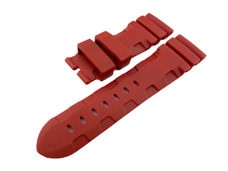 May include: A red rubber watch strap with a textured design and a buckle.