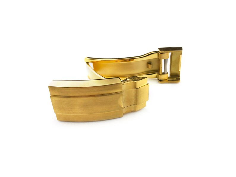 K&ouml;nnte beinhalten: Ein goldfarbener Uhrenarmbandverschluss mit geb&uuml;rsteter Oberfl&auml;che. Der Verschluss ist ge&ouml;ffnet und bereit, an ein Uhrenarmband befestigt zu werden.