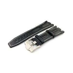 May include: Black leather watch strap with white stitching and a silver buckle.