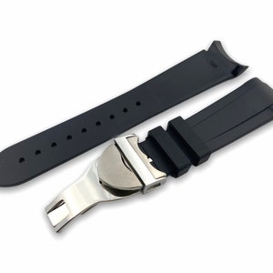 K&ouml;nnte beinhalten: Schwarzes Kautschuk-Armband mit einer silbernen Schlie&szlig;e. Das Armband hat eine strukturierte Oberfl&auml;che und ist f&uuml;r eine Uhr mit gebogenen Anst&ouml;&szlig;en konzipiert.