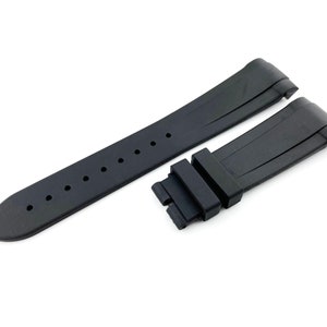 K&ouml;nnte beinhalten: Schwarzes Kautschuk-Armband mit einer Schlie&szlig;e. Das Armband hat eine strukturierte Oberfl&auml;che und ist f&uuml;r eine Uhr mit einer Bandansto&szlig;breite von 22 mm ausgelegt.