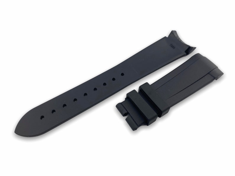 K&ouml;nnte beinhalten: Schwarzes Kautschuk-Armband mit einer Schlie&szlig;e und L&ouml;chern zum Einstellen der Gr&ouml;&szlig;e.