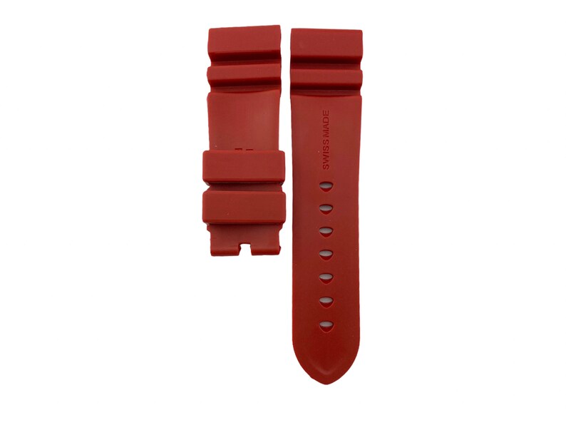 May include: A red rubber watch strap with the text "Swiss Made" printed on the strap.
