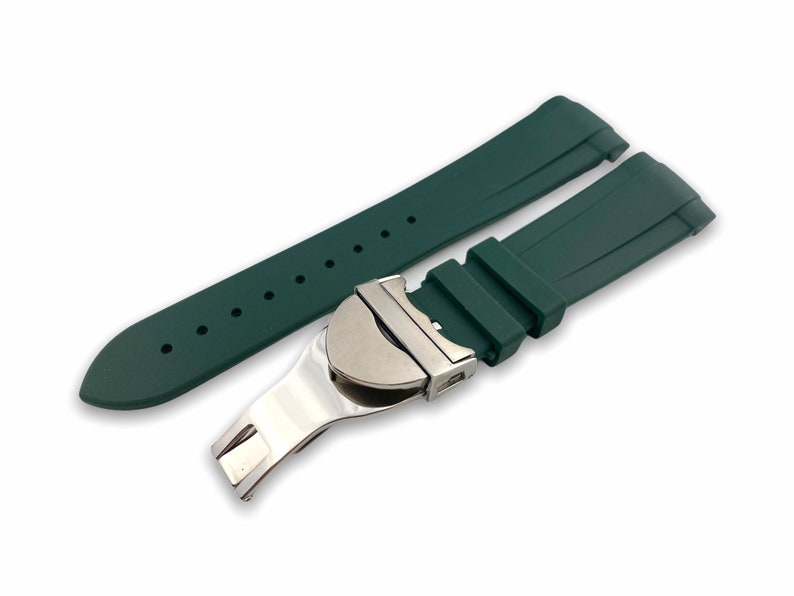 May include: A dark green silicone watch strap with a silver buckle. The strap has a textured surface and is designed for a watch with a 22mm lug width.