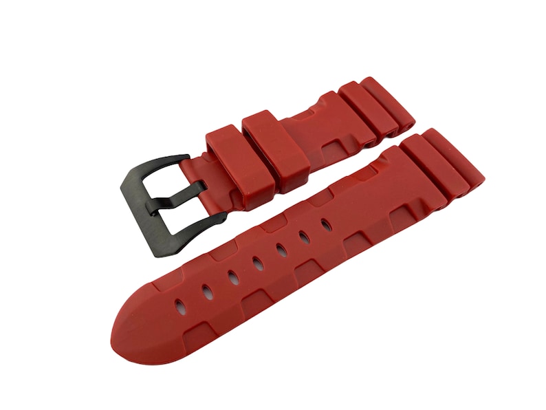 May include: A red silicone watch strap with a black buckle. The strap has a textured design and is designed for a watch with a 22mm lug width.