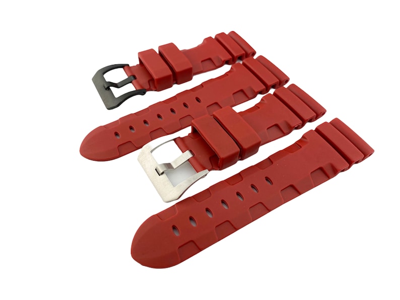 May include: Three red silicone watch straps with black and silver buckles. The straps have a textured design and are designed for a watch.