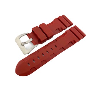 May include: A red silicone watch strap with a silver buckle. The strap has a textured design and is designed for a watch with a 22mm lug width.