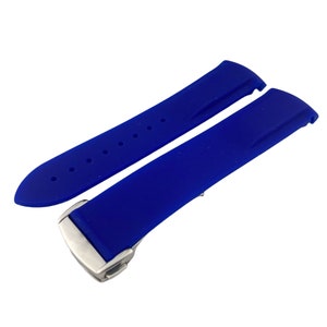 Może przedstawiać: Pasek do zegarka wykonany z niebieskiego silikonu z srebrną klamrą.