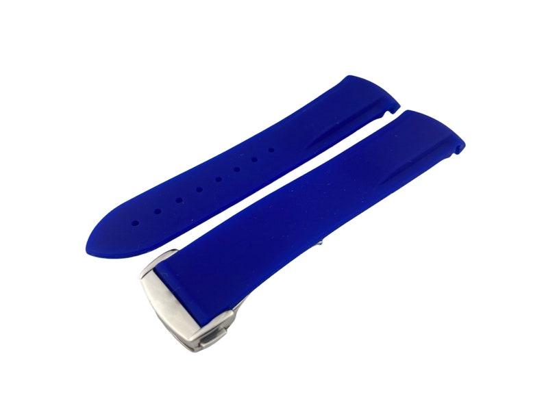 Może przedstawiać: Pasek do zegarka wykonany z niebieskiego silikonu z srebrną klamrą.