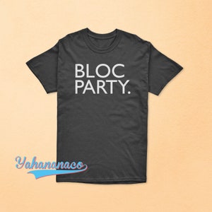 May include: A dark gray t-shirt with the text "BLOC PARTY." printed in white.