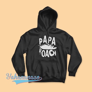Puede incluir: Sudadera con capucha negra con un gráfico blanco de una cucaracha y el texto "Papa Roach".