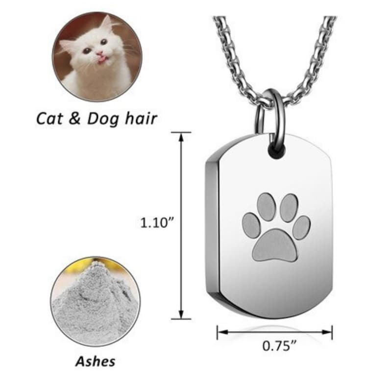 May include: Silver paw print cremation pendant necklace with a chain. The pendant is 1.10 inches tall and 0.75 inches wide. It can hold ashes, cat or dog hair.