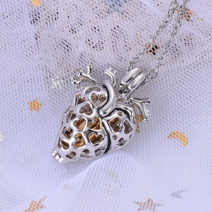 May include: A silver heart-shaped locket necklace with a delicate chain. The locket is open and features a detailed design of smaller hearts.