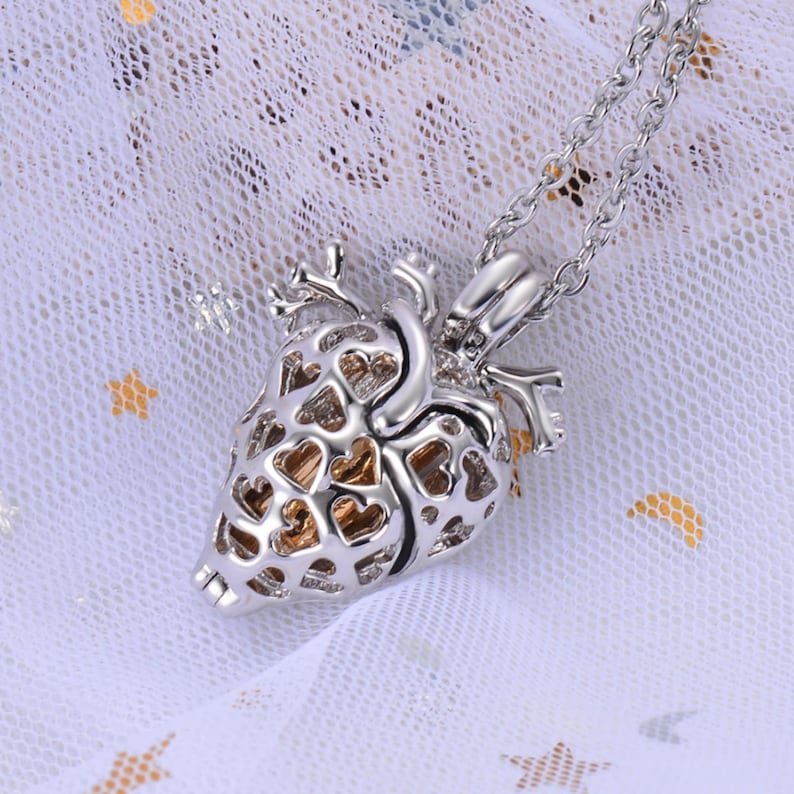 May include: A silver heart-shaped locket necklace with a delicate chain. The locket is open and features a detailed design of smaller hearts.