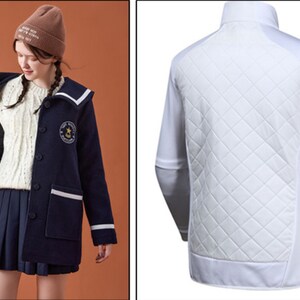 May include: A navy blue jacket with a white collar and white trim. The jacket has a button closure and a patch on the left side with a star and the text "Starlight Academy".