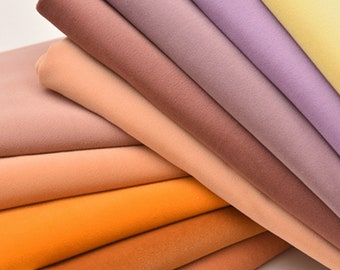 May include: A stack of fabric swatches in various shades of brown, orange, and purple. The fabric is soft and smooth, with a subtle sheen.
