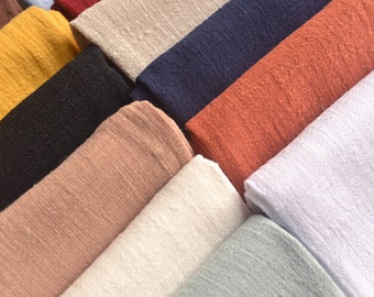 May include: A collection of fabric swatches in various colors, including yellow, black, brown, white, blue, orange, and green. The fabric has a textured, linen-like appearance.