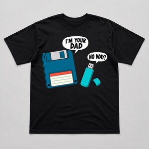 May include: A black short-sleeve t-shirt featuring a graphic of a blue floppy disk and a light blue USB flash drive. The floppy disk has a speech bubble saying I'M YOUR DAD and the USB drive has a speech bubble saying NO WAY! in white text.