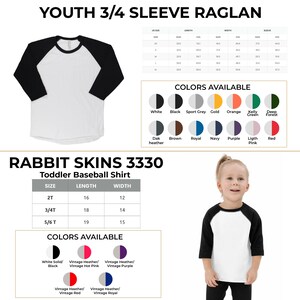 May include: A white toddler baseball shirt with black sleeves. The shirt is available in a variety of colours and sizes. The shirt is made by Rabbit Skins and is labelled as style 3330. The size chart shows the length and width of the shirt in inches.