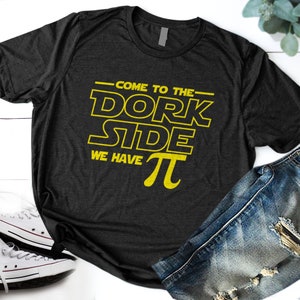 May include: A black t-shirt with yellow text that reads "Come to the Dork Side We Have Pi".