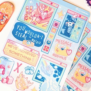 May include: A selection of vibrant stickers and sticker sheets showcasing cartoon robot characters and retro computer interface designs. The stickers feature text including "Cybertron", "Last Light", and "Message".