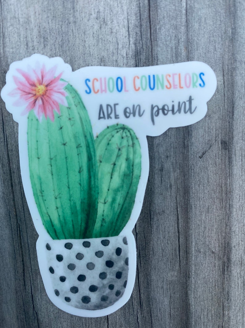 May include: A sticker with a watercolor illustration of a cactus in a polka dot pot. The text "SCHOOL COUNSELORS ARE on point" is written in rainbow colors above the cactus.