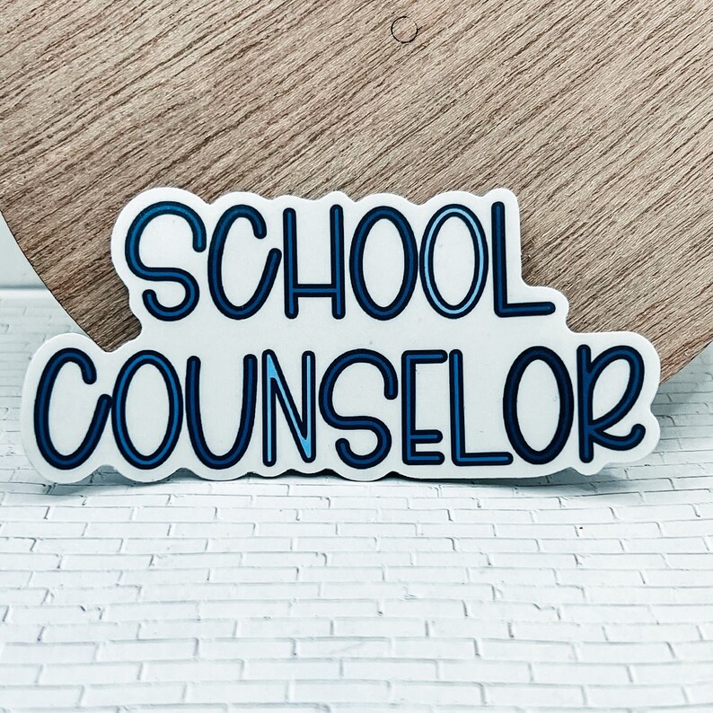 May include: A white sticker with blue outline lettering that reads "SCHOOL COUNSELOR".