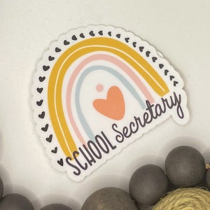 May include: A rainbow sticker with a heart in the center and the text "SCHOOL Secretary".
