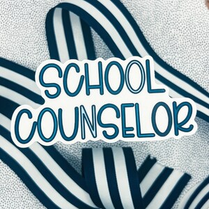 May include: White sticker with blue outline, reading "SCHOOL COUNSELOR" in a bold, playful font. The sticker is placed on top of a blue and white striped ribbon.