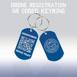 Könnte beinhalten: Blauer Drohnenpiloten-Schlüsselanhänger mit einem QR-Code und dem Text "Registered Drone Pilot". Auf der anderen Seite des Schlüsselanhängers befindet sich das Logo der Federal Aviation Administration.