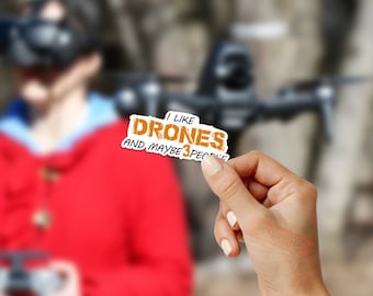 May include: A white sticker with orange text that reads "I like drones and maybe 3 people".