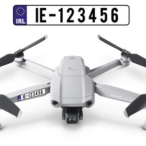 Puede incluir: Un dron DJI Mavic Air 2 blanco con hélices negras. El dron tiene una pegatina en el lateral que dice "IE-123456".
