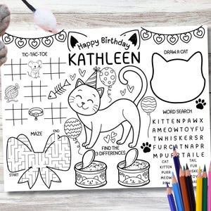Pode incluir: Tapete de atividades em preto e branco com tema de gato. Apresenta uma ilustração de gato, caça-palavras, labirinto, jogo da velha e o texto "Happy Birthday KATHLEEN". Inclui uma área de desenho e uma seção para encontrar diferenças.