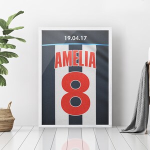May include: A white and black striped football jersey with the number 8 in red and the name Amelia in red. The date 19.04.17 is printed at the top of the jersey.