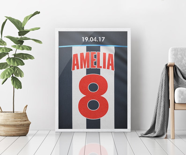 May include: A white and black striped football jersey with the number 8 in red and the name Amelia in red. The date 19.04.17 is printed at the top of the jersey.