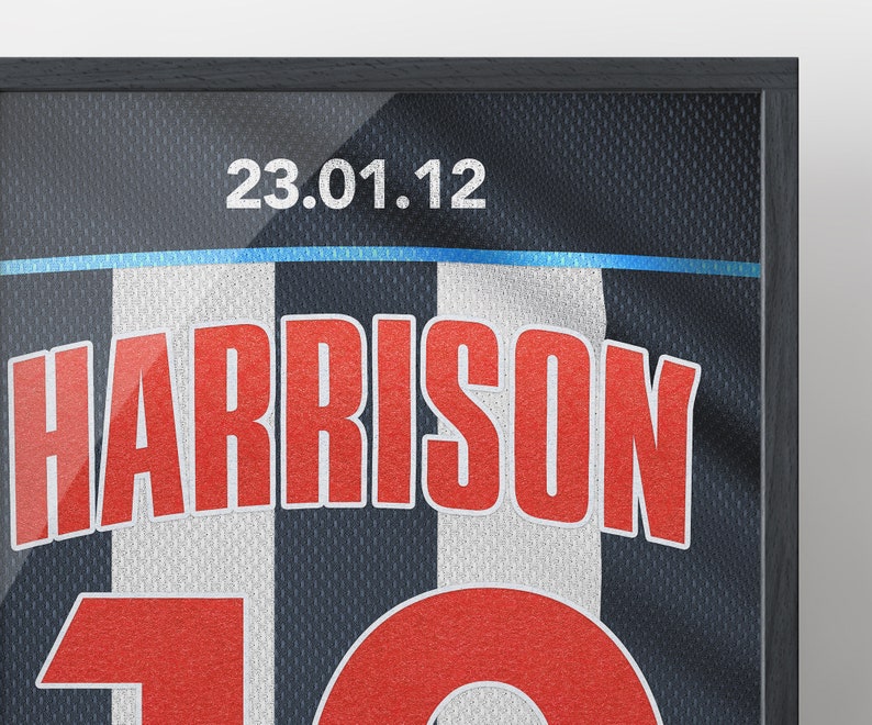 May include: A framed black and white jersey with the name "HARRISON" and the number "10" in red. The date "23.01.12" is printed at the top of the jersey.