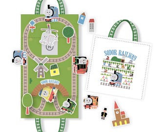 May include: A green and brown felt playmat with a train track design. The playmat has a handle and comes with various Thomas the Tank Engine character stickers. The stickers include a helicopter, a train, and a church.
