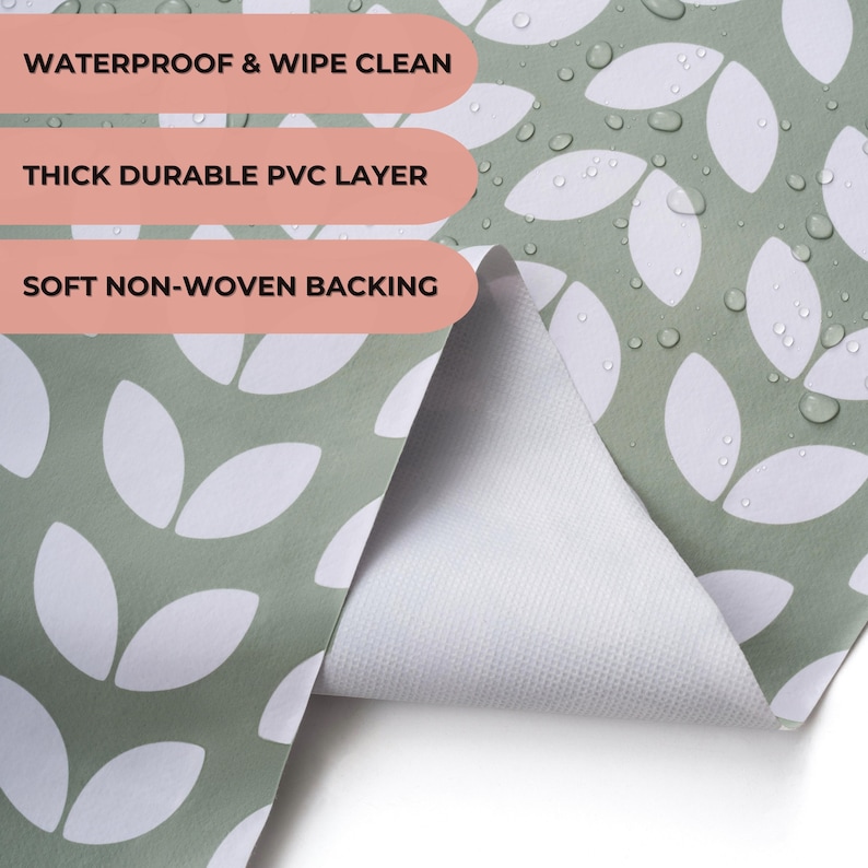 May include: Close-up of a green and white patterned fabric. The fabric features a repeating leaf design in white against a green background. The text on the image reads: "WATERPROOF & WIPE CLEAN", "THICK DURABLE PVC LAYER", and "SOFT NON-WOVEN BACKING".