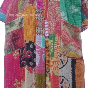 Könnte beinhalten: Eine bunte Patchwork-Decke mit verschiedenen Stoffen und Mustern. Die Decke ist aus Baumwolle und handgenäht. Sie hat eine grüne Tasche auf der rechten Seite.