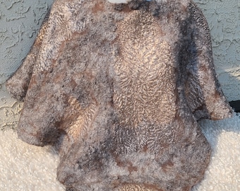 Poncho delicato traforato in feltro. Infeltrito su base di tessuto di seta, di lana merino e decorato con fibre di alpaca e tencel