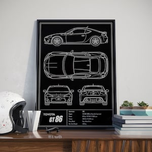 May include: A black and white line art print of a Toyota GT86 car. The print shows the car from different angles, including side, top, front, and rear views. The print also includes the car's specifications, such as engine size, power, and weight.