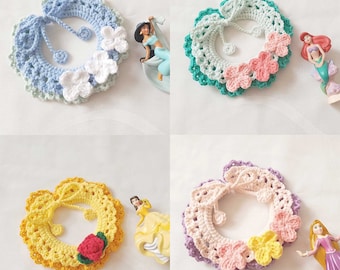 May include: Four crocheted collars with different colored flowers. The collars are in shades of blue, green, yellow, and purple.