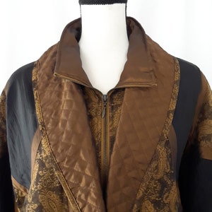 Peut inclure: Une veste matelass&eacute;e marron et noire avec un motif paisley. La veste a une fermeture &eacute;clair et un col montant.