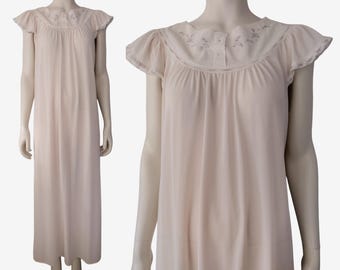 May include: A pale pink, sleeveless nightgown with a white lace trim and floral embroidery around the neckline. The nightgown has a button closure at the neckline.