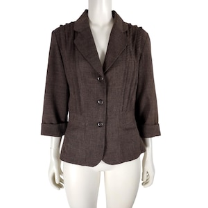 May include: A brown blazer with a fitted silhouette and three buttons. The blazer has a notched collar and long sleeves with rolled cuffs.